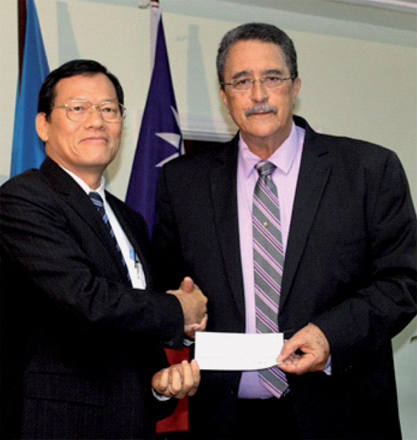 Taiwanese Ambassador James Chang presents cheque for CDP to Prime Minister Anthony. [PHOTO: Stan Bishop]