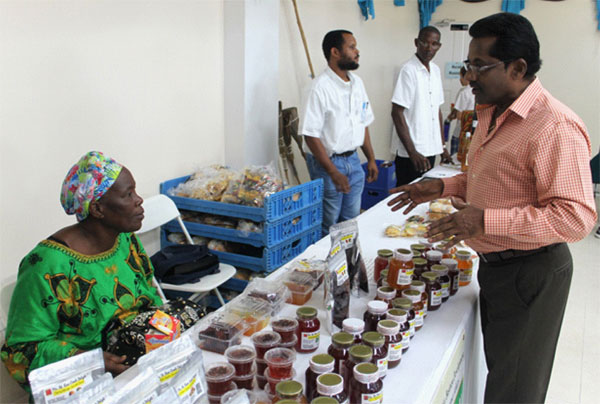 Baron Foods Ltd's Managing Director, Ronald Ramjattan, offering some advice to one of the trade exhibition's participants yesterday. [Photo: Stan Bishop]