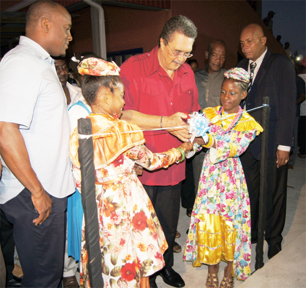 Prime Minister and Parliamentary representative for Vieux Fort South Dr. Kenny Anthony cutting the ribbon to officially put on the lights. [Photo: Anthony De Beaville]
