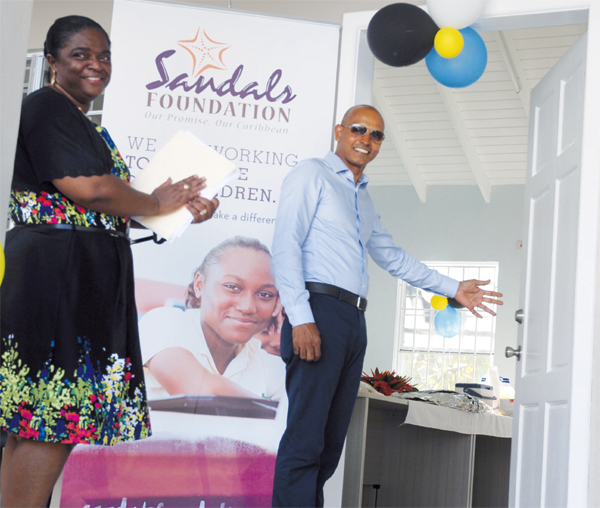 Regional Director for Sandals Resorts International Andre Dhanpaul opens the doors to the newly renovated and outfitted Fond St. Jacques Community Center on Sunday signaling its official opening.
