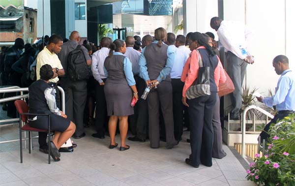 Bank of Saint Lucia employees being apprised by trade union representative outside Bridge Street branch last Tuesday. [Photo: Stan Bishop]