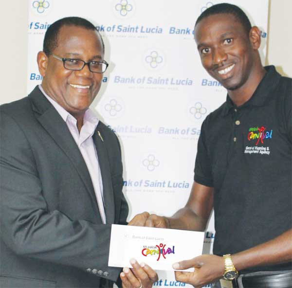 Image of BOSL General Manager HadynGittens which presents the Bank’s sponsorship cheque to Devernant Joseph of the Carnival Planning and Management Agency (CPMA).