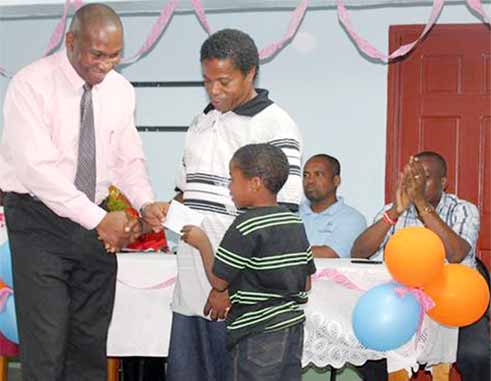 Education Minister Dr. Robert Lewis presents bursaries