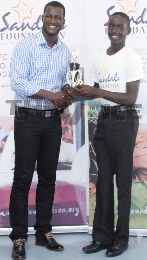 (L-R) Darren Sammy presenting Kimani Melius with the Most Outstanding Cricketer Award. (PHOTO: Anthony De Beauville)