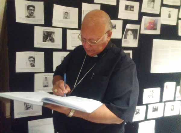 Image: Archbishop Rivas signs the Condolence Book.