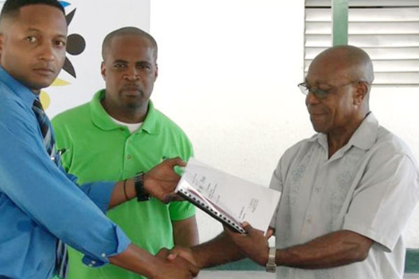 Image of Dalson (right) receiving plans for the project