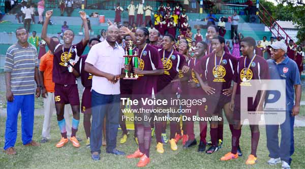 Image: Sports minister Shawn Edward presenting Soufriere captain Keeroy Lionel with the Under-19 football championship trophy. (PHOTO: Anthony De Beauville)