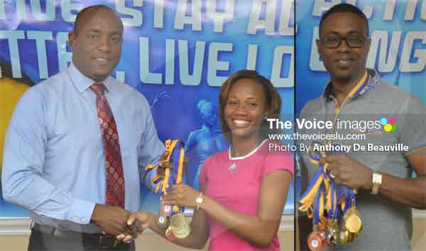 Image: Minister presenting medals to representatives from District 3 SolangePettie and Lorne Theophilus District 7. (PHOTOS BY: Anthony De Beauville)