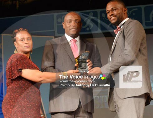 Image:L SLFA executive members Liz Campbell (L) and Chad Desir (R) receiving the Association of the Year award from the Minister for Youth Development and Sports Shawn Edward