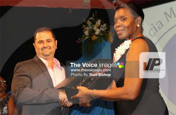 Image: Commerce Minister Emma Hippolyte presents this year’s Minister’s Award for Innovation to a representative from Du Boulay’s Bottling Co. Ltd. [PHOTO: Stan Bishop]