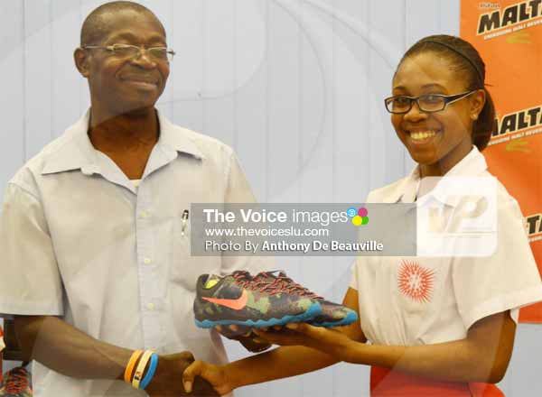 Image: Youth and Sports Officer Ligorious Marquis presenting a pair of track shoes to a CCSS student [PHOTOl Anthony De Beauville]