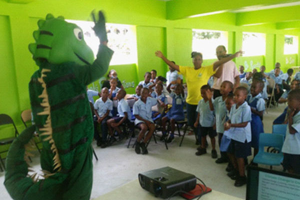 img: Igy the iguana educating the students of Fond Assau Primary on land degradation
