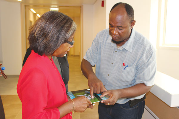 img: Minister Issac studies a piece of hospital equipment