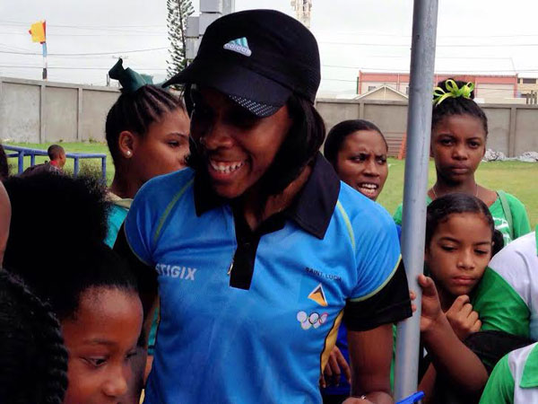 img: Olympian Levern Spencer with children at the 759 Champions Tour in St. Lucia