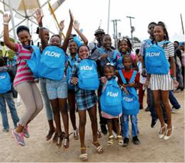 img: Students pose for the cameras with their brand new school bags received at FLOW Skool Aid 2016.