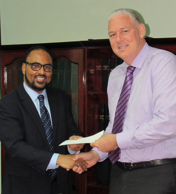 img: Isaac Anthony presents payout cheque to Prime Minister Allen Chastanet. 