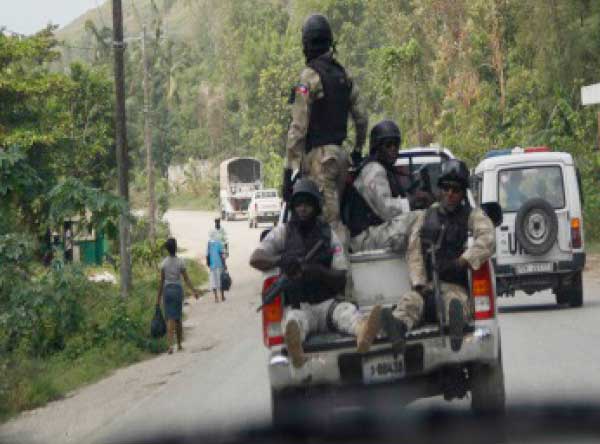 Image: Haitian police officers prevent other vehicles from overtaking a UN convoy. (CMC photo)