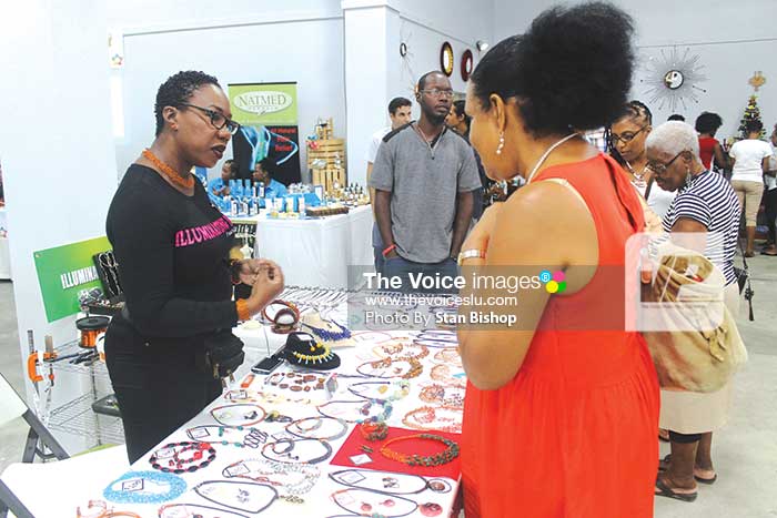Image: Terril Nicholas (left) explaining to a curious customer some of the items she specializes in. [PHOTO: Stan Bishop]