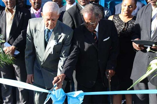 Image: The symbolic ribbon cutting was performed by two founding fathers of the St. Lucia Co-operative League, namely Emmanuel Theodore (L) and Haydn Williams. [PHOTO: By PhotoMike]