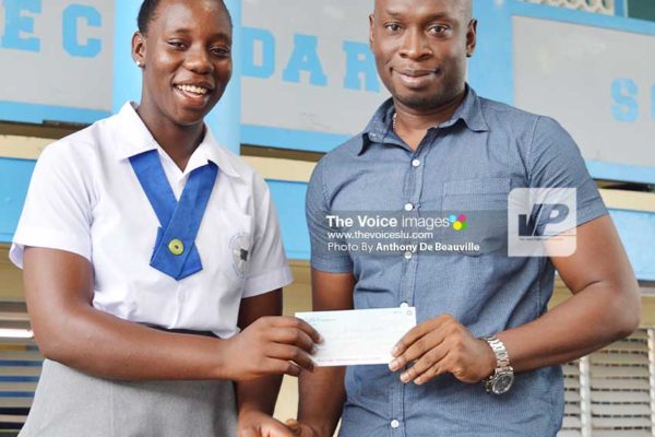 Image: (l-r) Qiana Joseph receiving a $500.00 cheque from Beauty Max’s Nickson Pierre