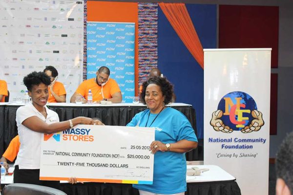 Image: Massy Stores’ Sariah Best-Joseph pledging the company’s $25,000 contribution to NCF’s Executive Director, Michelle Phillips.