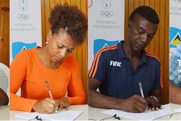 Image: (L-R) Some of the signatories, Roger Butcher (Rugby), Rochelle Jn. Baptiste (Athletics), Cess Podd (SLFA) and Oliver Lawrence (Karate) signing documents indicating receipt of funding from the SLOC. (Photo: Anthony De Beauville)