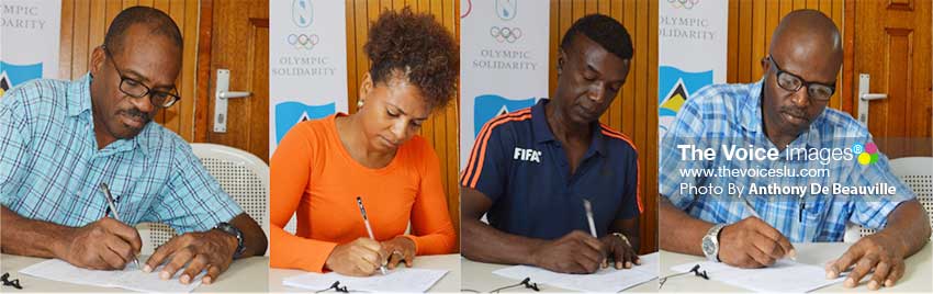 Image: (L-R) Some of the signatories, Roger Butcher (Rugby), Rochelle Jn. Baptiste (Athletics), Cess Podd (SLFA) and Oliver Lawrence (Karate) signing documents indicating receipt of funding from the SLOC. (Photo: Anthony De Beauville)