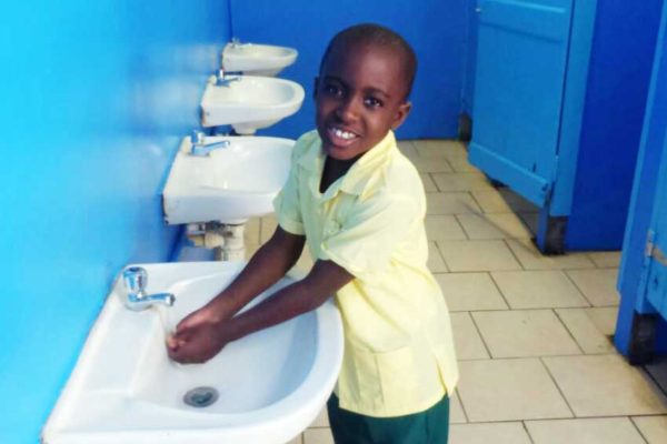 Image of one of the Balata Government School students making use of the refurbished bathroom facility at his school.