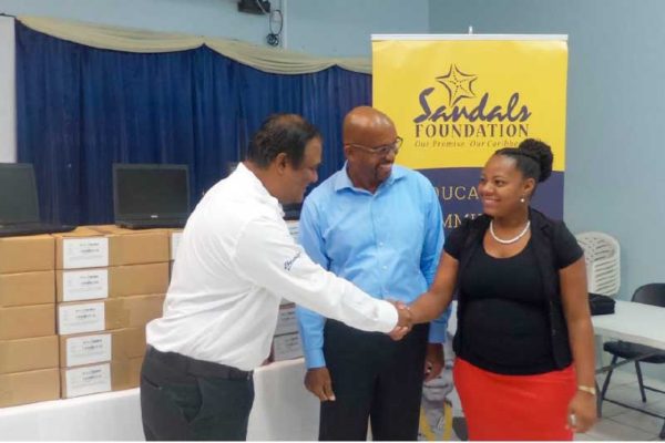 Image: Regional Public Relations Manager for Sandals Resorts in the Eastern Caribbean, Sunil Ramdeen, (left) presents the 20 laptop computers to TSOBE officials on Monday.