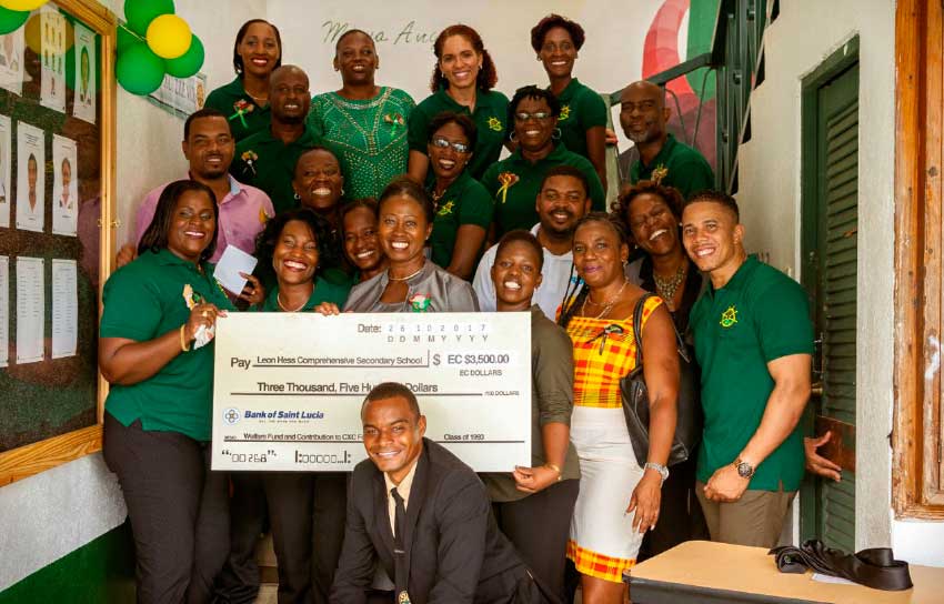Image: Group photo with cheque, next to newly-unveiled noticeboard at the school.
