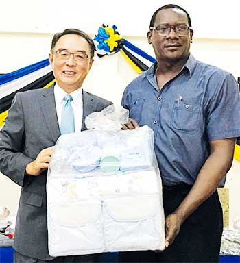 Image of His Excellency Ambassador Douglas Shen handover the sample of charity supplies to the Honourable Lenard Montoute