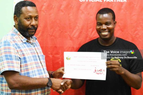 Image: (L-R) SLFA President Lyndon Cooper presenting the 1st place cheque of EC$25,000 to a representative of the Marchand Football League for winning the inaugural Coca Cola Island Cup 2018. (Photo: Anthony DeBeauville)