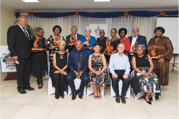 Image: Left to Right Standing: (recipients of the Pelican Awards) Awardees: Drs. Ian and Jacqueline Walwyn (receiving on behalf of their father Dr. R. Alford Walwyn), Mrs. Dancia Penn, QC, Dr.HeskithVanterpool, Dr. Beverley Steele, Dr.Jillia Bird, Dr. Veronica Simon, H.E. Dame Pearlette Louisy, H.E. Dr.Didacus Jules, Ms. Rene Baptiste, CMG, Front Row Seated: Director Alumni Relations, Mrs. Celia Davidson-Francis, Vice Chancellor, Professor Sir Hilary Beckles, Pro Vice Chancellor and Principal Open Campus, Dr. Luz Longsworth, Chancellor Robert Bermudez, Open Campus Alumni Officer, Mrs. Sandra Griffith-Carrington.