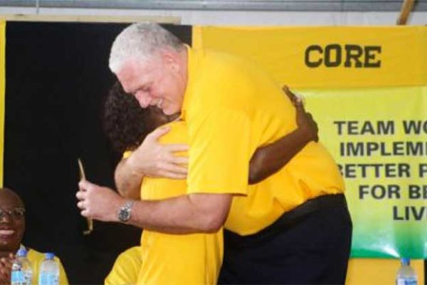 Image of PM Allen Chastanet and a member of the UWP embracing at the party convention