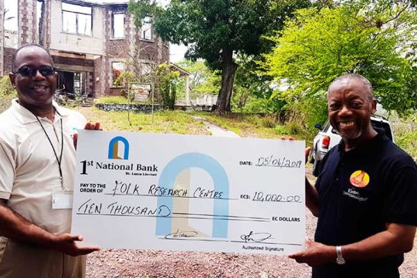 Image of 1st National Bank’s Executive Manager for Marketing and PR Robert Fevrier (left) presenting the cheque to FRC Founder Msgr. Patrick Anthony.