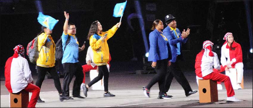 Image: Chef de Mission, David "Shakes" Christopher (extreme right), and Assistant to the Chef de Mission, Velica Augustin (beside him), followed by volunteers due to the absence of Saint Lucian coaches and athletes excluding Flag Bearer Luc Chevrier during Friday's March Pass at Friday's Opening Ceremony. (PHOTO: David R Pascal)