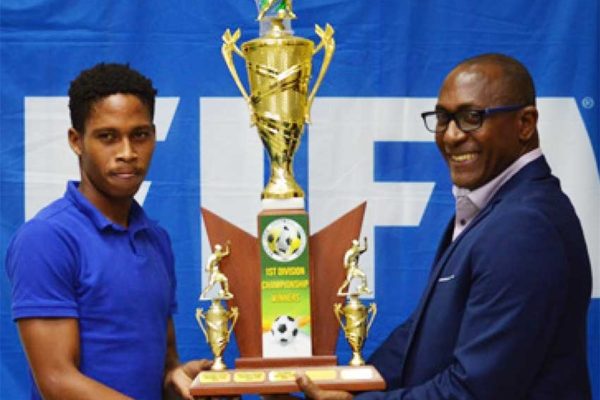 Image: (L-R) A representative from Platinum FC receiving the championship trophy from Chairman National Lotteries Authority – Caron Serieux; Best Goalkeeper, Noah Didier receiving his award from Permanent Secretary in the Ministry for Youth Development and Sports – Benson Emille. (PHOTO: Anthony De Beauville)