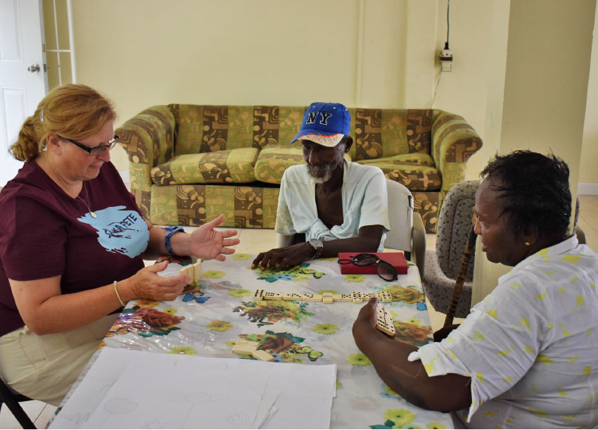 Image: Charlotte Mathurin playing dominos with residents. 