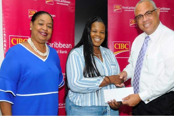 Image: CIBC FirstCaribbean’s Managing Director, Retail and Business Banking Mark St Hill (right) making the presentation to Tamika Roberts, President of the Bahamas Students Association (centre) while Business Development Officer at UWI Cave Hill, Sonia Johnson shares in the moment.