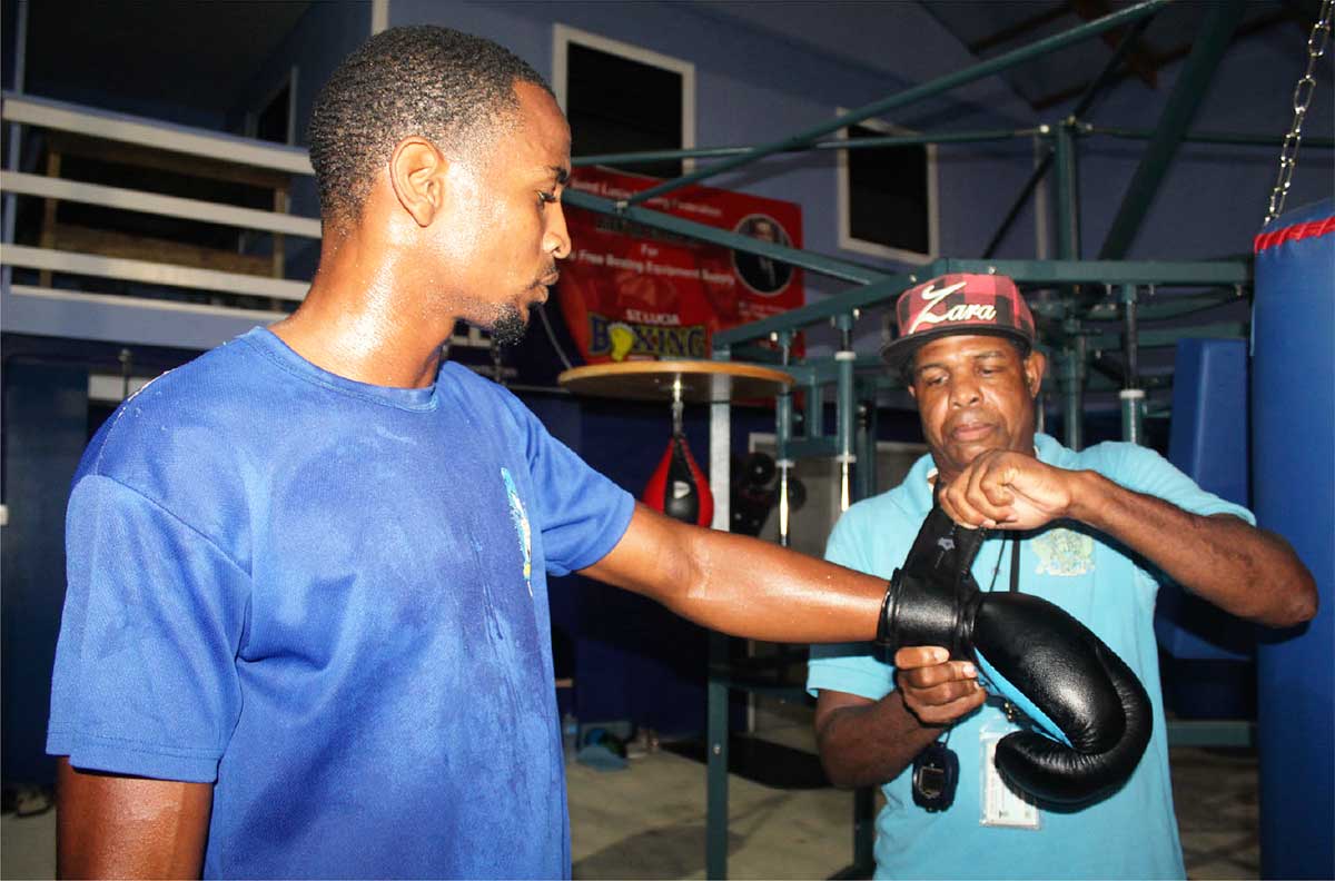 Coach Conard Ferdericks (r) assisting Boxer Kyghan Mortley, at the Vigie Boxing Gym.