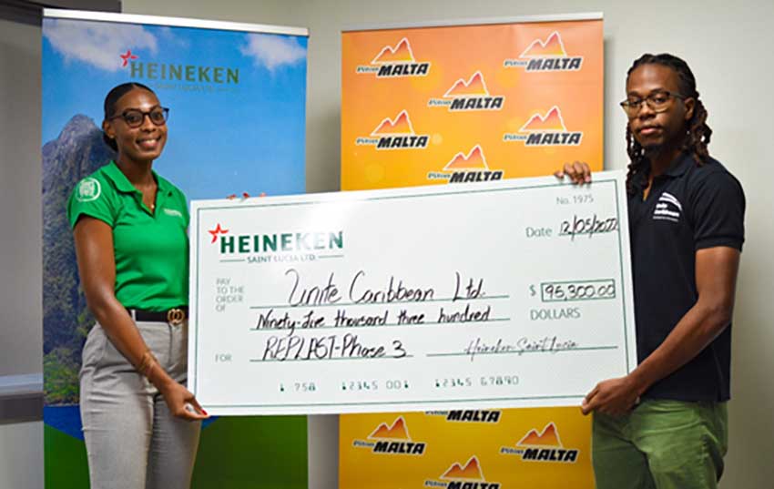 McAllister Hunte (r) of Unite Caribbean receives investment cheque from Heineken Saint Lucia Ltd.’s Corporate Affairs Manager, Louise Victor.