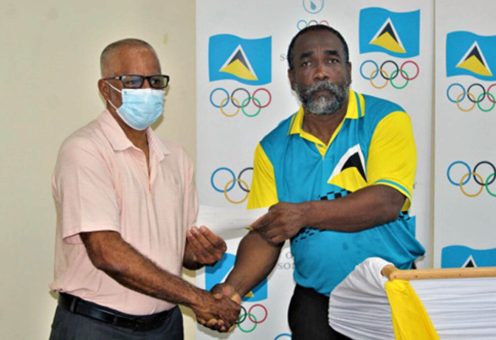 St. Lucia Aquatics Federation president, Eddie Hazell, left, receives a cheque for EC$12,067.00 from SLOC Inc. president, Alfred Emmanuel, last Wednesday.