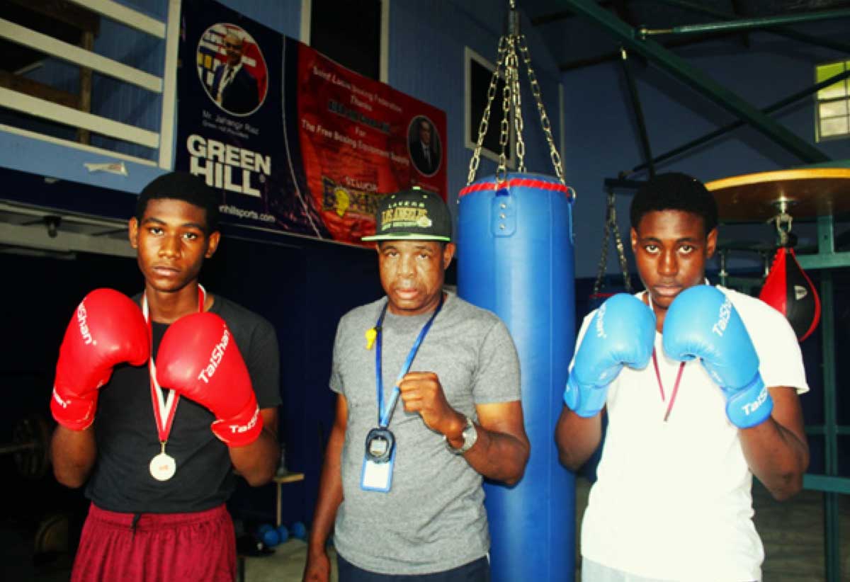 Youth boxers Herve Charlemagne (left) and Kevert Similien (right) with Coach Conrad Fredericks at the Vigie Boxing Gym on Thursday.