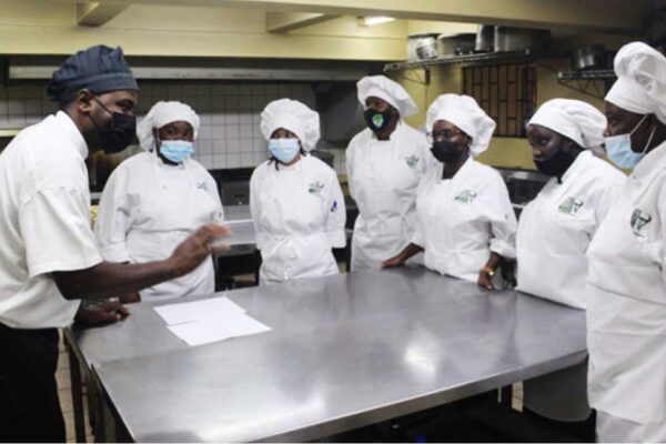 Instructor from SALCC (left) teaching students skills in the Hospitality vocational training course.