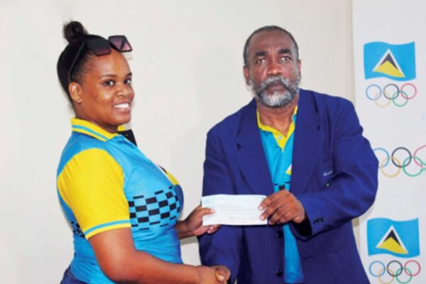 Kerin Neptune, senior volleyball player, left, accepting the cheque on her association’s behalf from SLOC Inc’s President, Alfred Emmanuel.