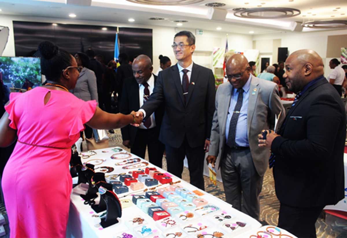 Ambassador Chen and His Excellency Cyril Charles, Acting Governor General, greet one of the exhibitors from Saint Lucia at the trade show.
