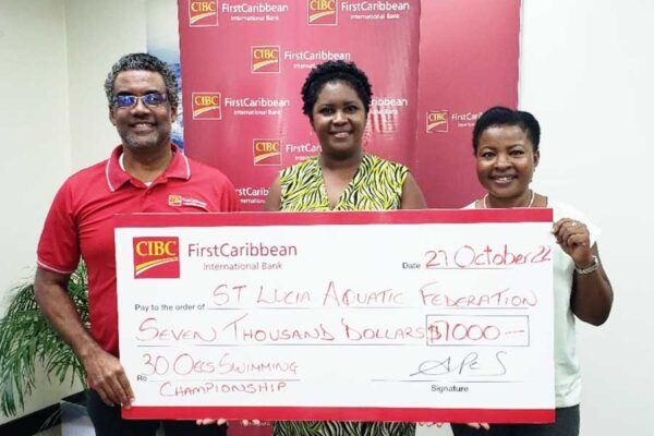 CIBC FCIB Country Manager at left presenting the cheque to representatives of the Saint Lucia Aquatic Federation.