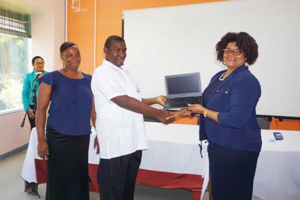 PS Pauline Antoine-Propsere presents a laptop to a secondary school student