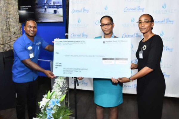 Michi Joseph, Coconut Bay Adventure Desk Manager (Left) and Anella Ruffin, the Finance Department Accounts Assistant at Coconut Bay Beach Resort & Spa (Right) Present Ava Peter, Principal of Vieux Fort Comprehensive Secondary School (Middle) with a $7,500 check for school restoration and construction.