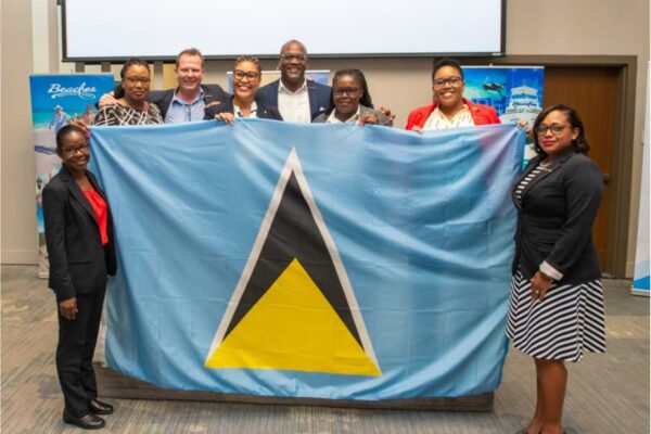 FLYING THEIR FLAG WITH PRIDE, AT SRI… Saint Lucia-born Financial Controllers took a minute off to fly their home flag at a major conference of counterparts in Jamaica, where their contributions to Sandals Resorts International (SRI) good financial health were roundly acknowledged by the global Caribbean hospitality chain’s Executive Chairman, Adam Stewart. (Left to Right): Antonia Ferdinand-Amedee, Mellisa John, [Regional Finance Director Barrie Corcoran] Aqualia Alexander, [Ryan Matthew, Corporate Director for Human Resources and also a Saint Lucian], Bernice Alfred, Ella Charles-Martin and Selma Ballantyne-Charles. (PHOTO: Courtesy SRI)